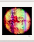A digital artwork of lips in a dark wood circular frame, showcasing vibrant multicolored streaks on a black background. Signed at the bottom right, this framed wall art is ideal for conscious interior design.