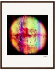 A circular abstract fine art print showcases central lips with multicolored streaks and splashes of red, purple, yellow, and green, elegantly displayed as framed wall art with a white mat and dark wood frame.