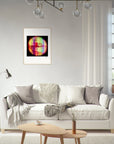 A modern living room with a white sofa, neutral cushions, a throw blanket, a small oval wooden coffee table, and a colorful fine art print in a gallery-quality frame hanging on the wall above the sofa.