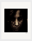 A grainy, dark-toned photograph shows a person's face partly obscured by shadows and strands of dark hair, with a serious expression. The image is bordered by a gallery-quality frame, perfect for mindful home decor.