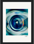 A close-up photo of a washing machine door with reflections and blue-green light effects. Framed wall art with a white mat, black border, and a signature in the lower right corner—perfect for mindful home decor.