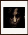 A dark, grainy close-up image of a person’s face with an intense expression, partially obscured by shadows and hair. This inspirational wall art is centered within a gallery-quality frame and white mat. A signature appears in the lower right corner.