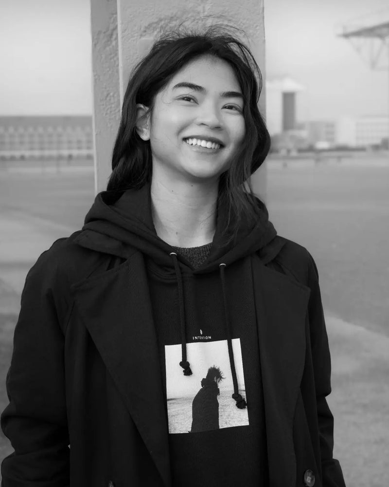 Strength, "Misty Mind" organic hoodie worn open over a coat on the harbour front