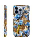 A phone case featuring a photo art close-up of multiple blue butterflies on grass, shown from the back and side angles. The word INTENTION appears near the bottom of the back, highlighting beautiful textures.