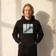 Jazzy - "Lacey Leg" Black Hoodie worn against a sunlit plaster wall