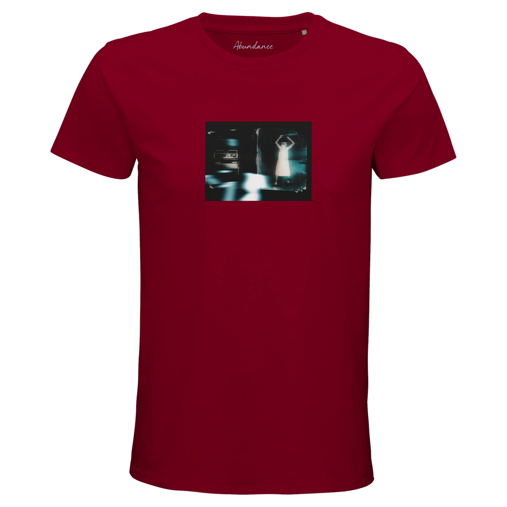A burgundy short-sleeve t-shirt with a small, rectangular art graphic of a blurry figure and cars on the chest. "Abundance" is printed at the neckline, making this mindful piece both unique and expressive.