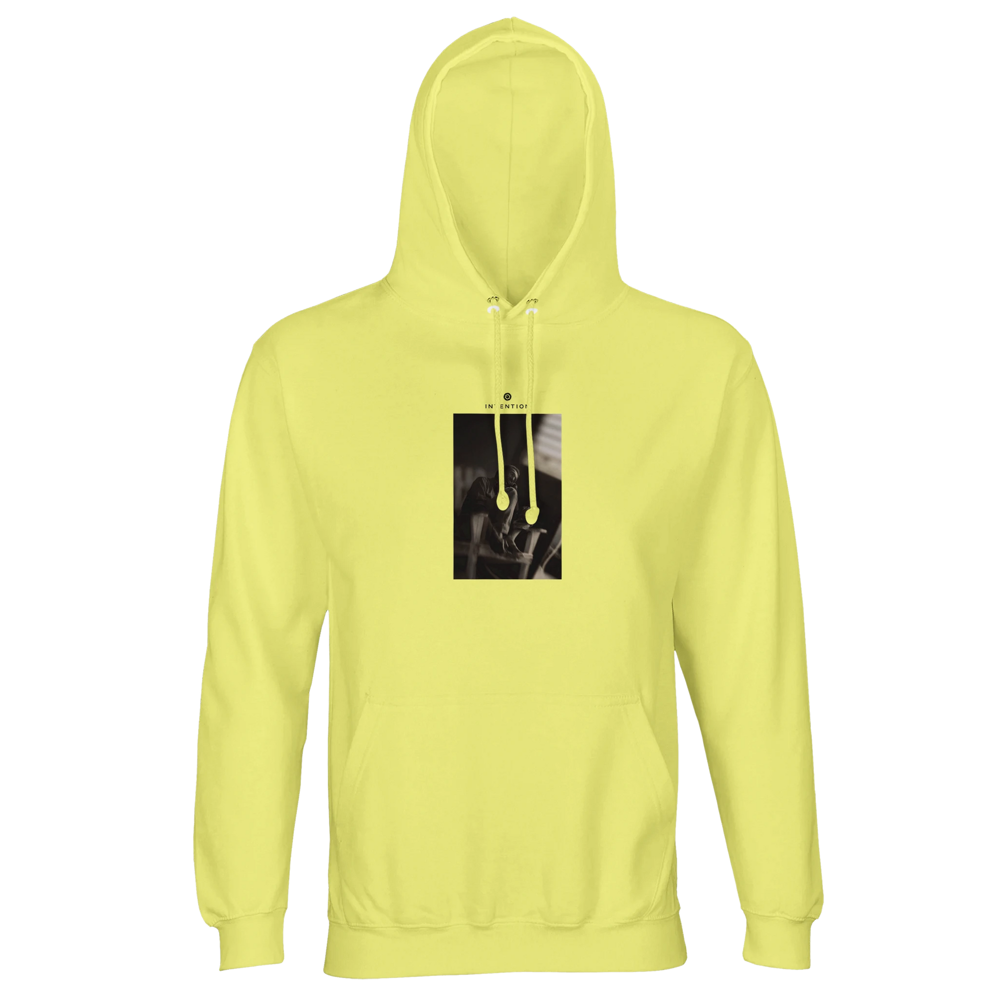 A light yellow hooded sweatshirt with matching drawstrings, featuring a small rectangular art print with a dark, indistinct image centered on the chest. Displayed against a plain white background.