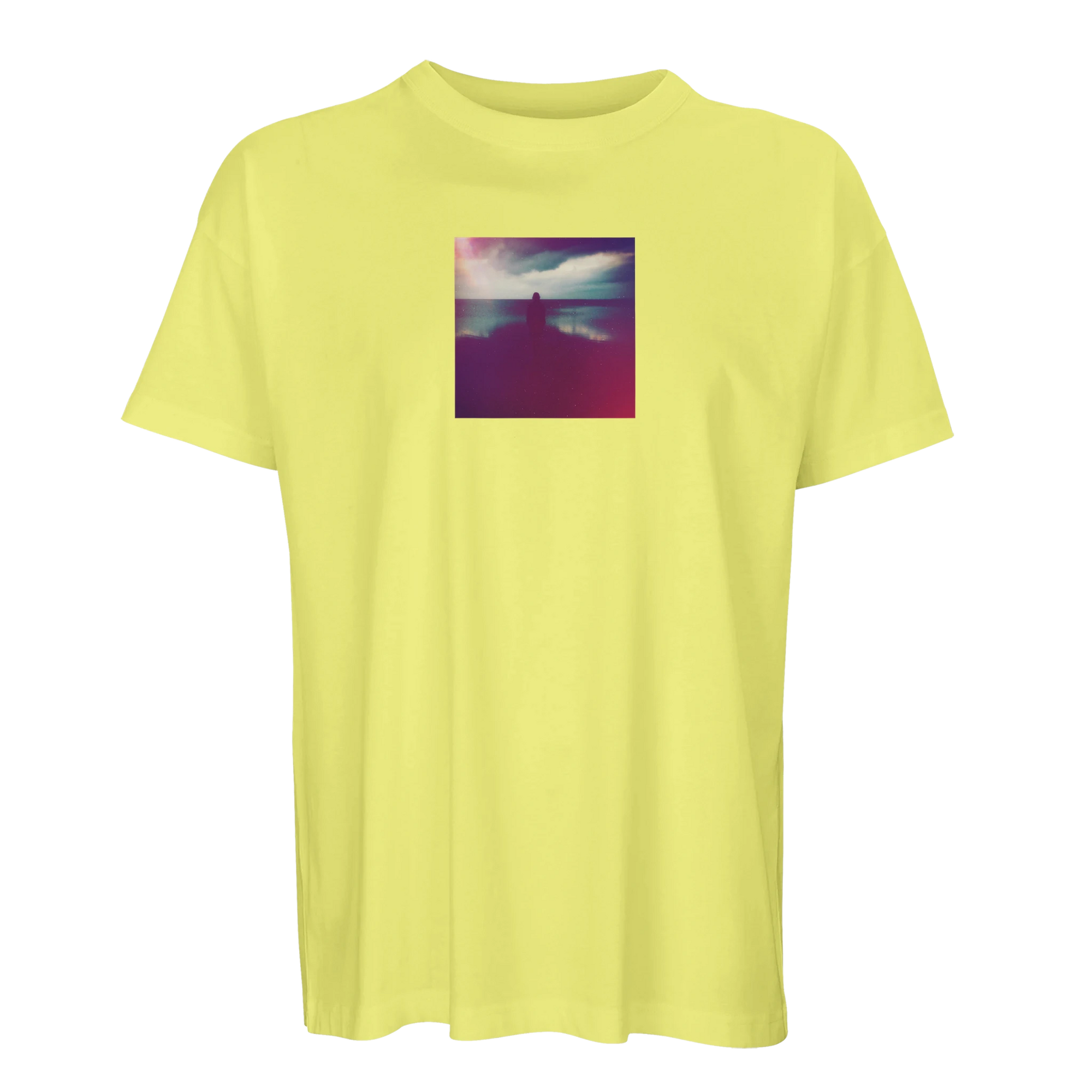 A light yellow short-sleeve t-shirt with a square, colorful photo print of a person by water under a cloudy sky, centered on the chest—designed for conscious fashion enthusiasts.