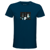 A denim t-shirt with an art print on the chest shows a blurred, blue-toned figure with raised arms by a car at night. "Abundance" is printed inside the collar, reflecting mindful apparel and conscious fashion.