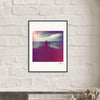 A framed photograph hangs on a white brick wall, serving as inspirational wall art. The gallery-quality frame surrounds a dreamy image of a silhouetted figure by water with purple and pink hues, perfect for conscious interior design.