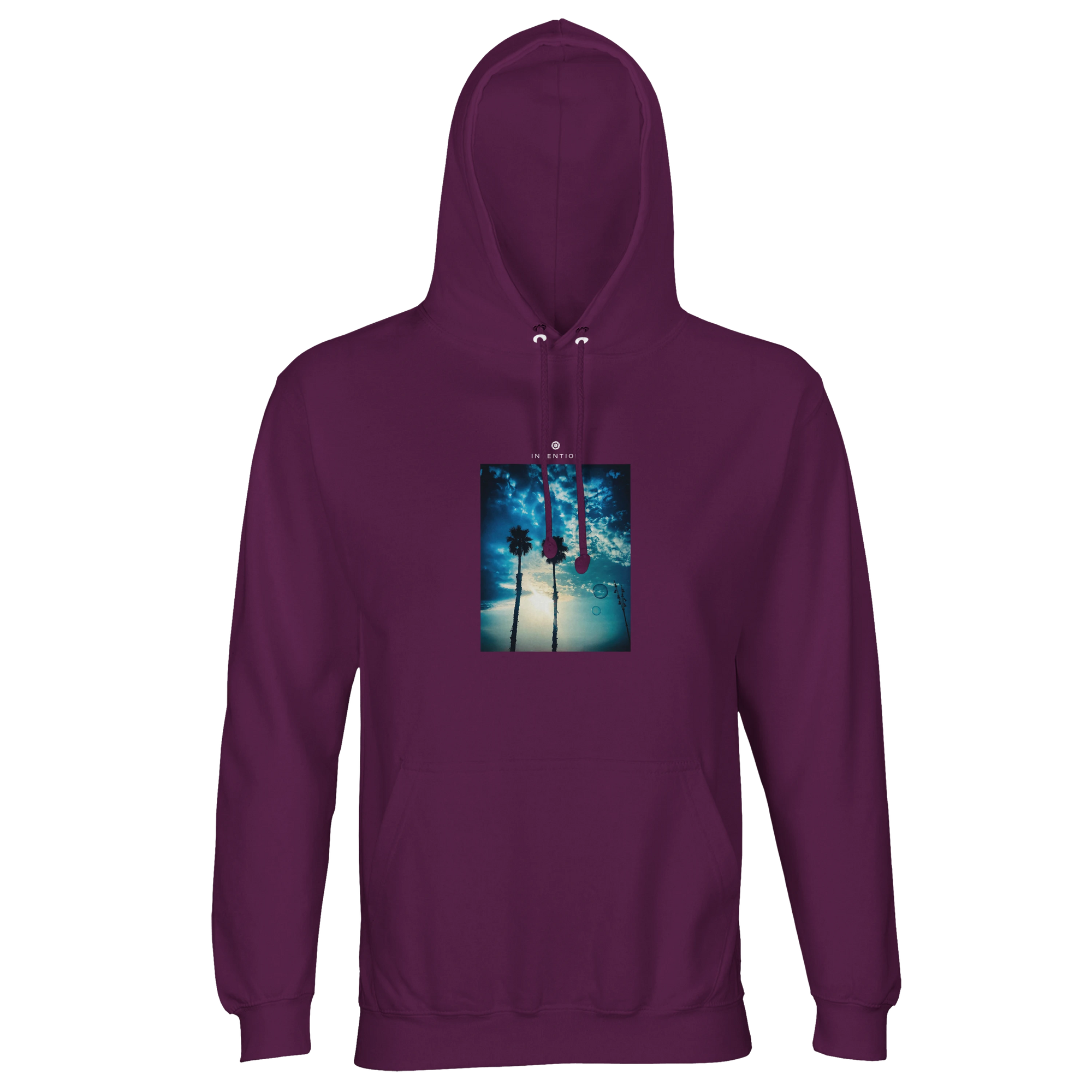 An astral purple hooded sweatshirt features a centered rectangular graphic of two tall palm trees under a bright sky with clouds and sunlight. Equipped with front pocket and drawstrings, it's mindful apparel that promotes conscious fashion.