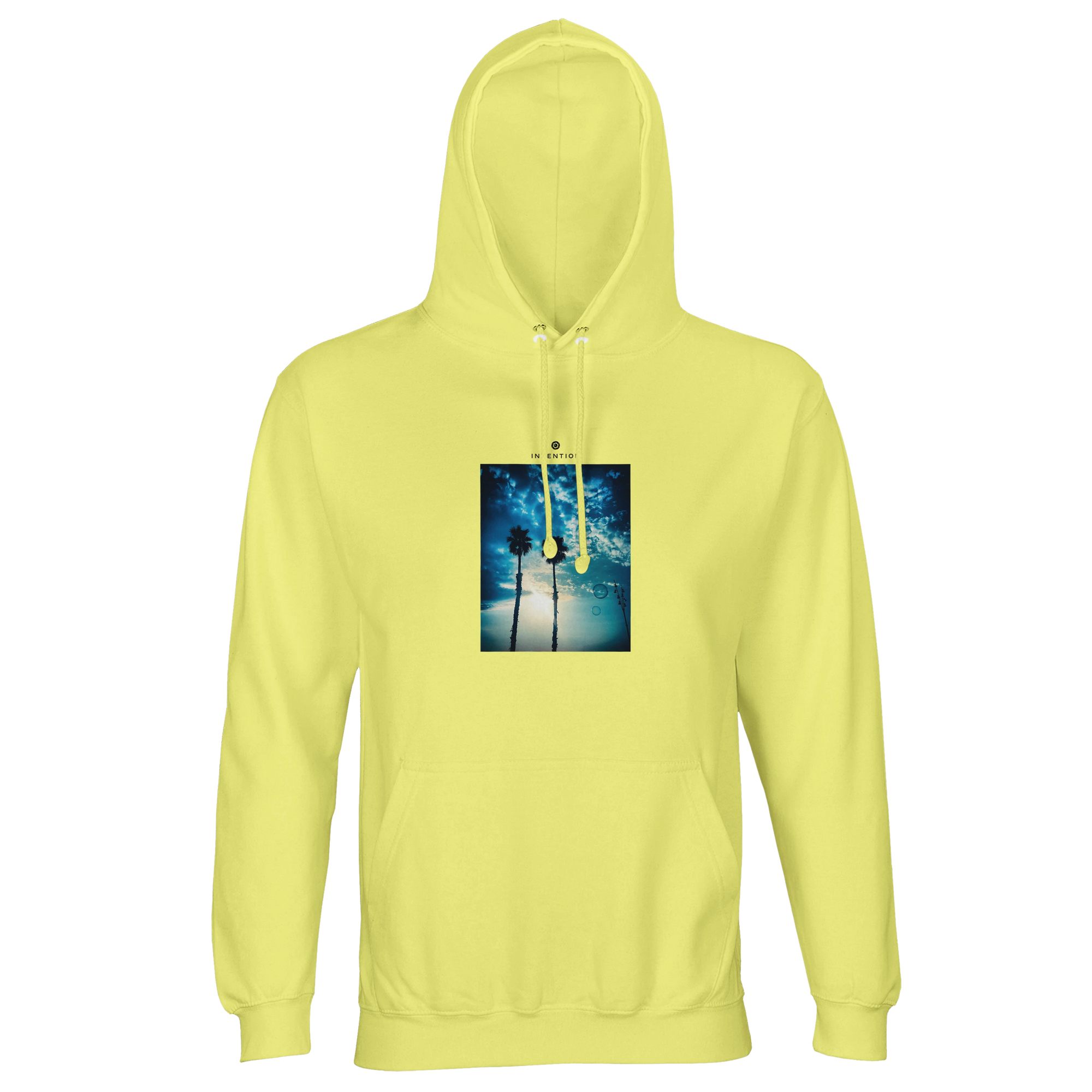 A light yellow hooded sweatshirt with an art print of two palm trees against a blue sky and sunlight filtering through branches, designed as mindful apparel for those who value style and conscious living.