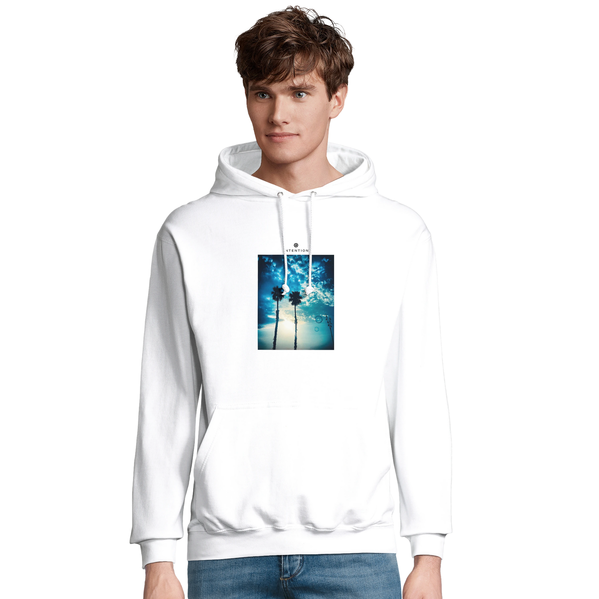 A young man wearing a white hoodie featuring a graphic print of two roses submerged in water on the front, paired with blue jeans, stands against a plain white background—showcasing conscious fashion and mindful apparel.