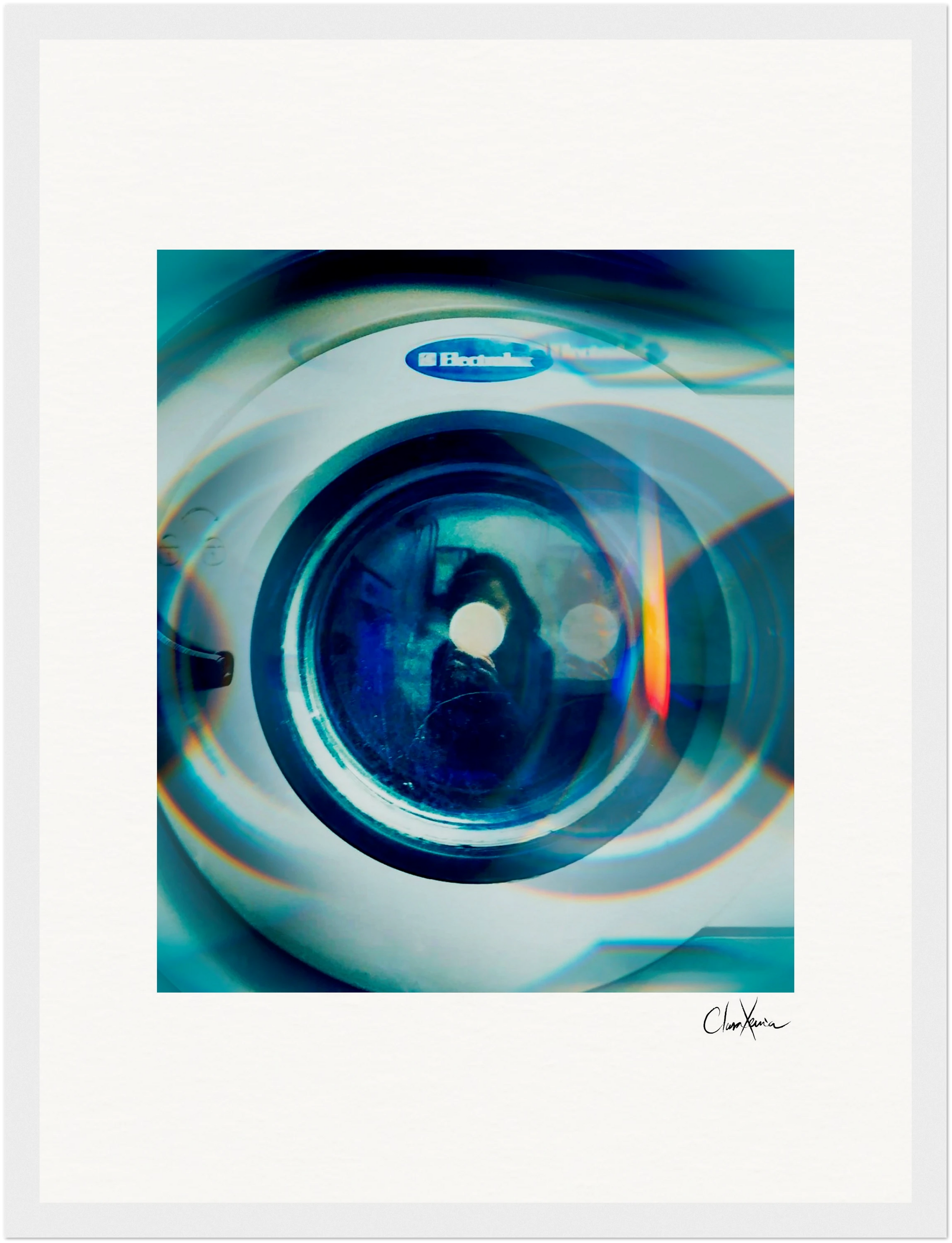 Close-up of a front-loading Electrolux washing machine door, seen through a blue-toned filter with reflections and a faint silhouette in the glass. Perfect as inspirational wall art, this fine art print is framed with a white border and signed at the bottom right.