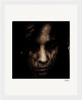 A grainy, dark-toned photograph shows a person's face partly obscured by shadows and strands of dark hair, with a serious expression. The image is bordered by a gallery-quality frame, perfect for mindful home decor.