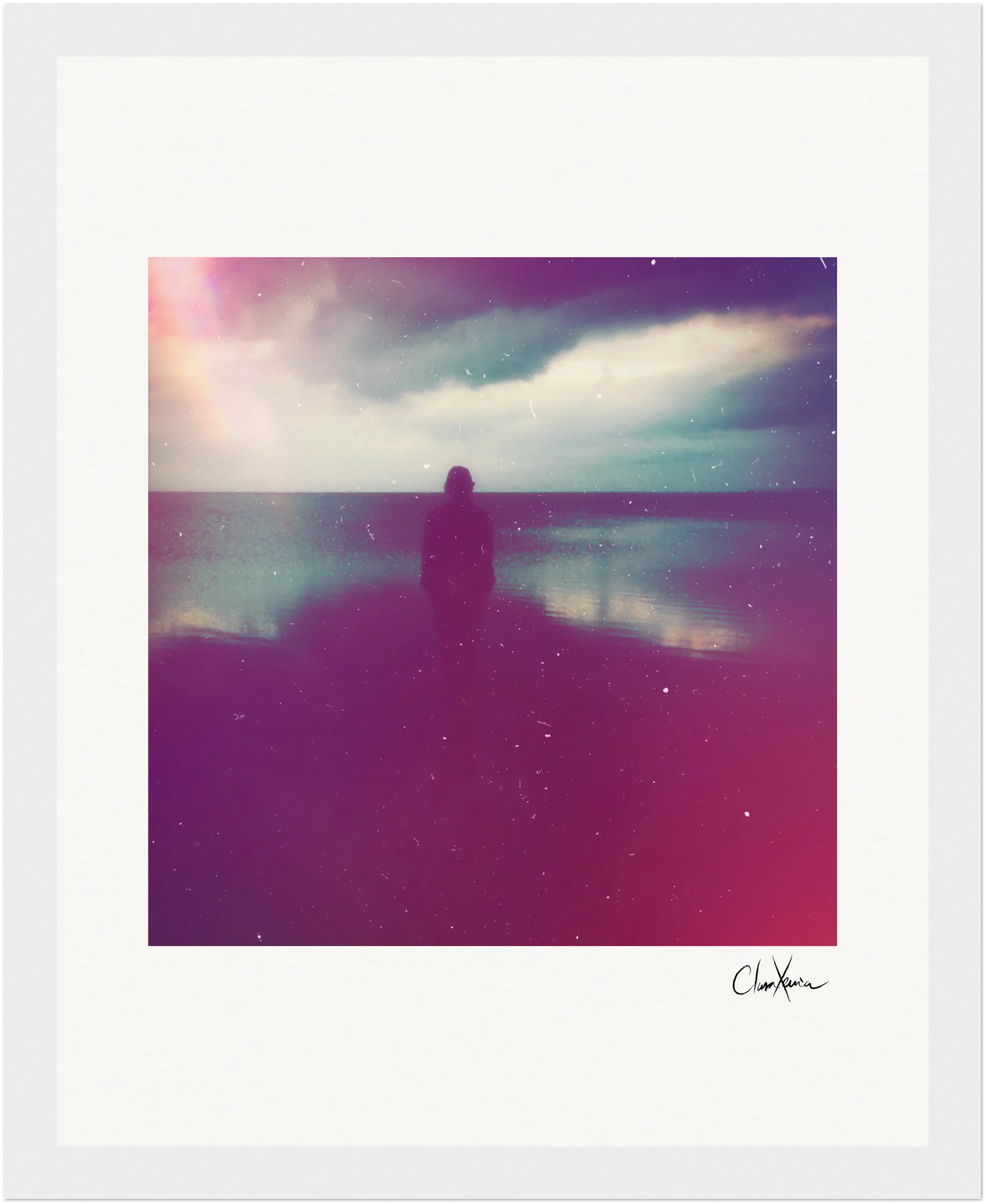 A silhouette of a person stands near calm water beneath a cloudy sky, accented by a dreamy overlay of pink, purple, and blue tones. Perfect as framed wall art, it brings a touch of mindful home decor to any space. Signature in the bottom right corner.