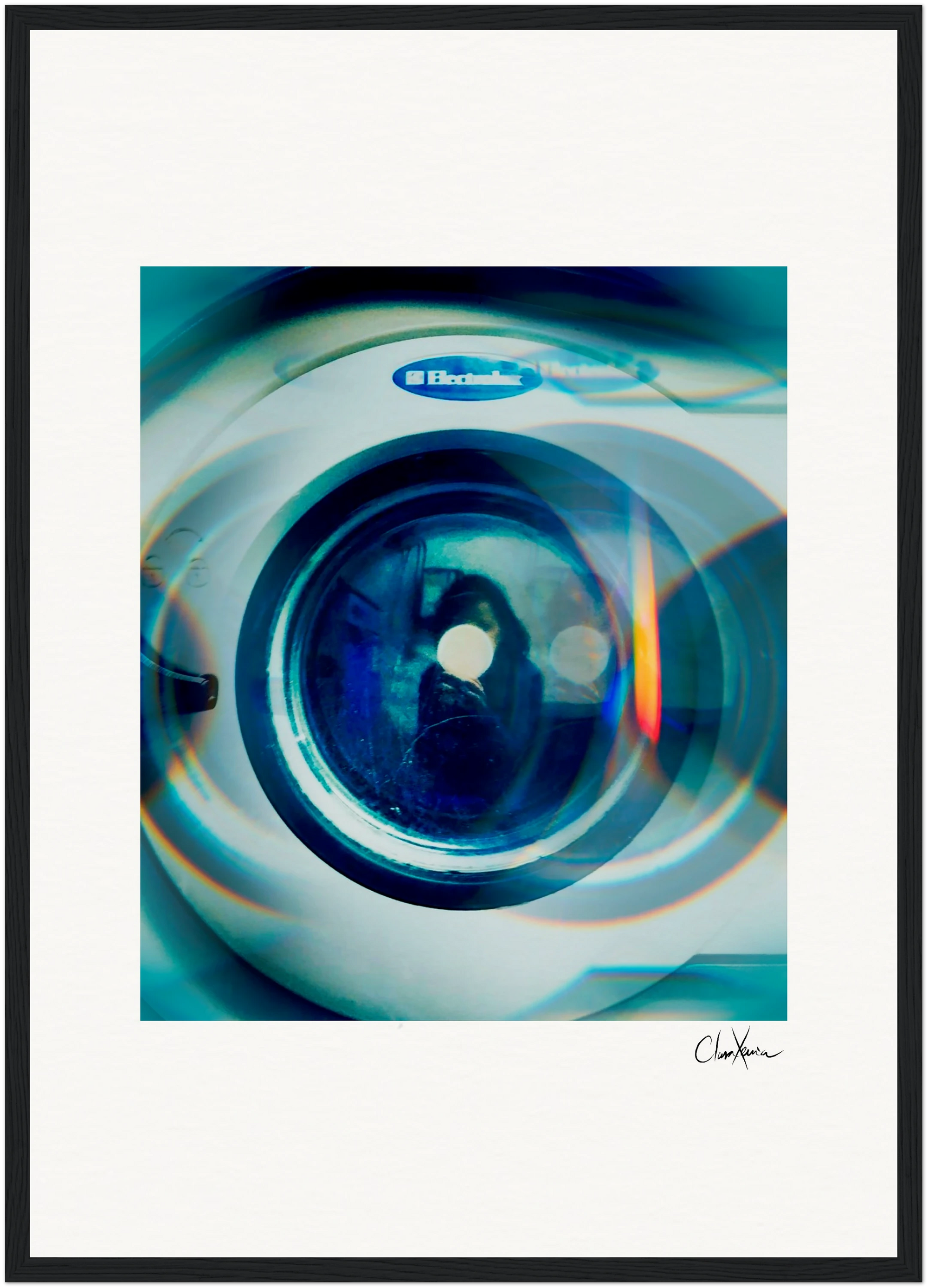 A close-up photo of the front door of an Electrolux washing machine, with blue and orange light reflections, a signature on the white background, and presented as framed wall art for a modern touch.