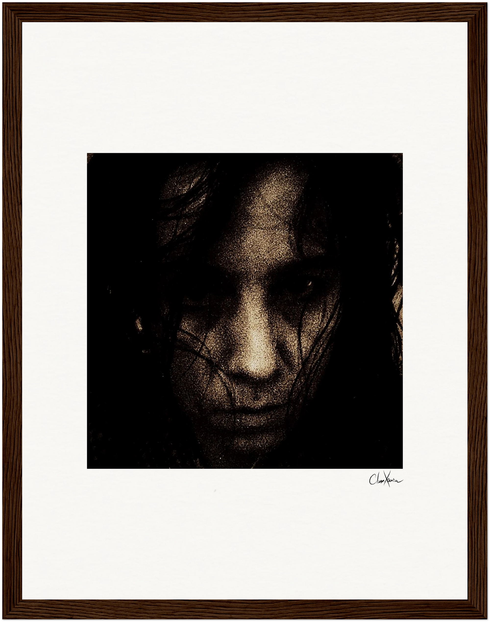 A close-up, dark-toned portrait of a face, partially obscured by shadows and dark hair, centered on a white background within a gallery-quality frame. A signature is visible on the lower right side—an inspirational wall art fine art print.