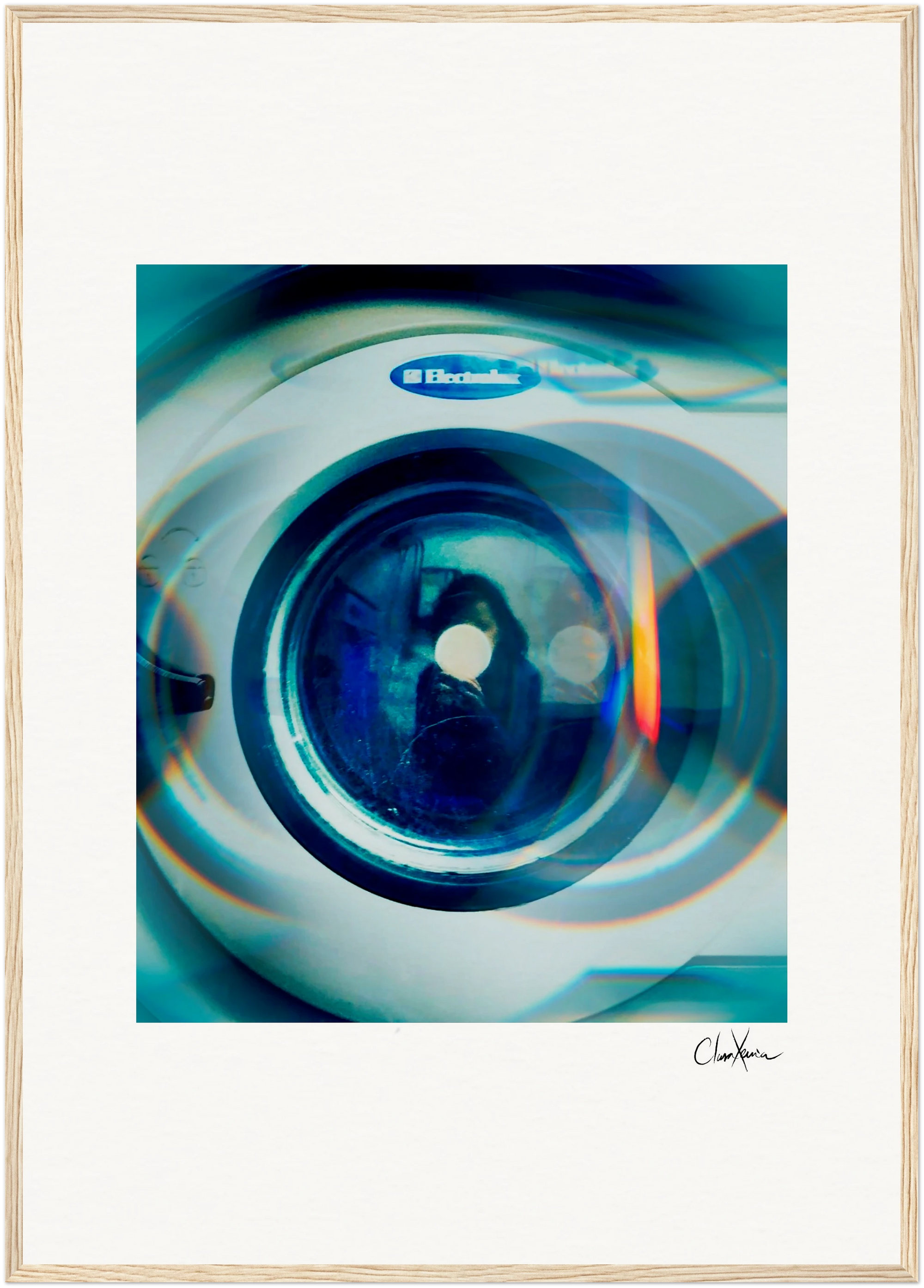 A front-loading Electrolux washing machine with a reflection on the round glass door, surrounded by blue and teal light effects; a white border frames this fine art print, and a signature appears at the bottom.