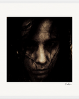 A grainy, dark-toned close-up of a person’s face with long hair partially covering it. The serious expression and white border, paired with a signature in the lower right, make this image striking framed wall art.