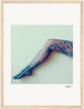 A single outstretched leg in patterned floral lace tights is set against a pale background with a soft, blurred effect. Framed in a gallery-quality frame, this piece brings mindful home decor to any conscious interior design. An artist’s signature appears below.