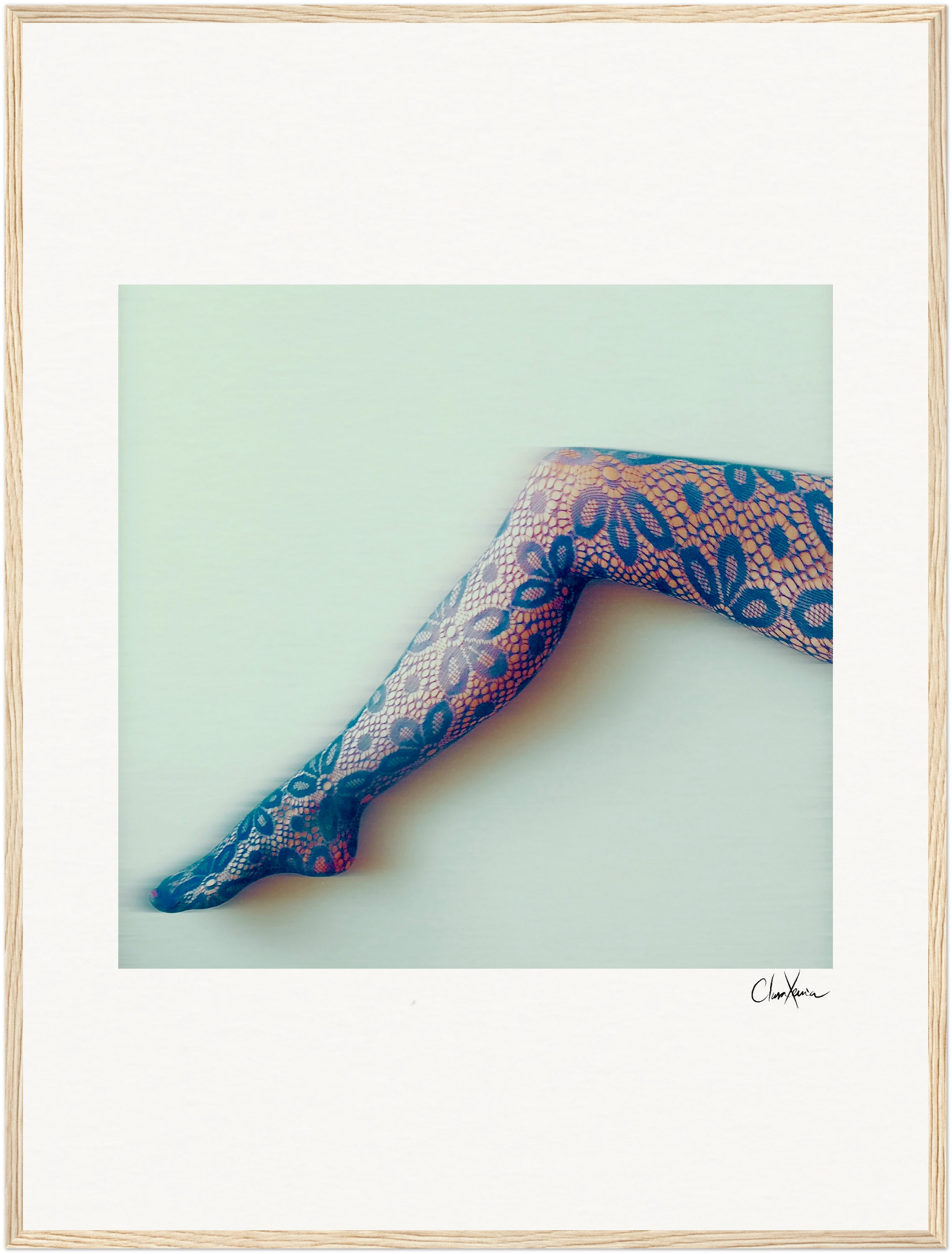 A single outstretched leg in patterned lace tights with a floral design is set against a light background. The image is elegantly framed with a gallery-quality frame and a light wood-like edge—perfect for mindful home decor.