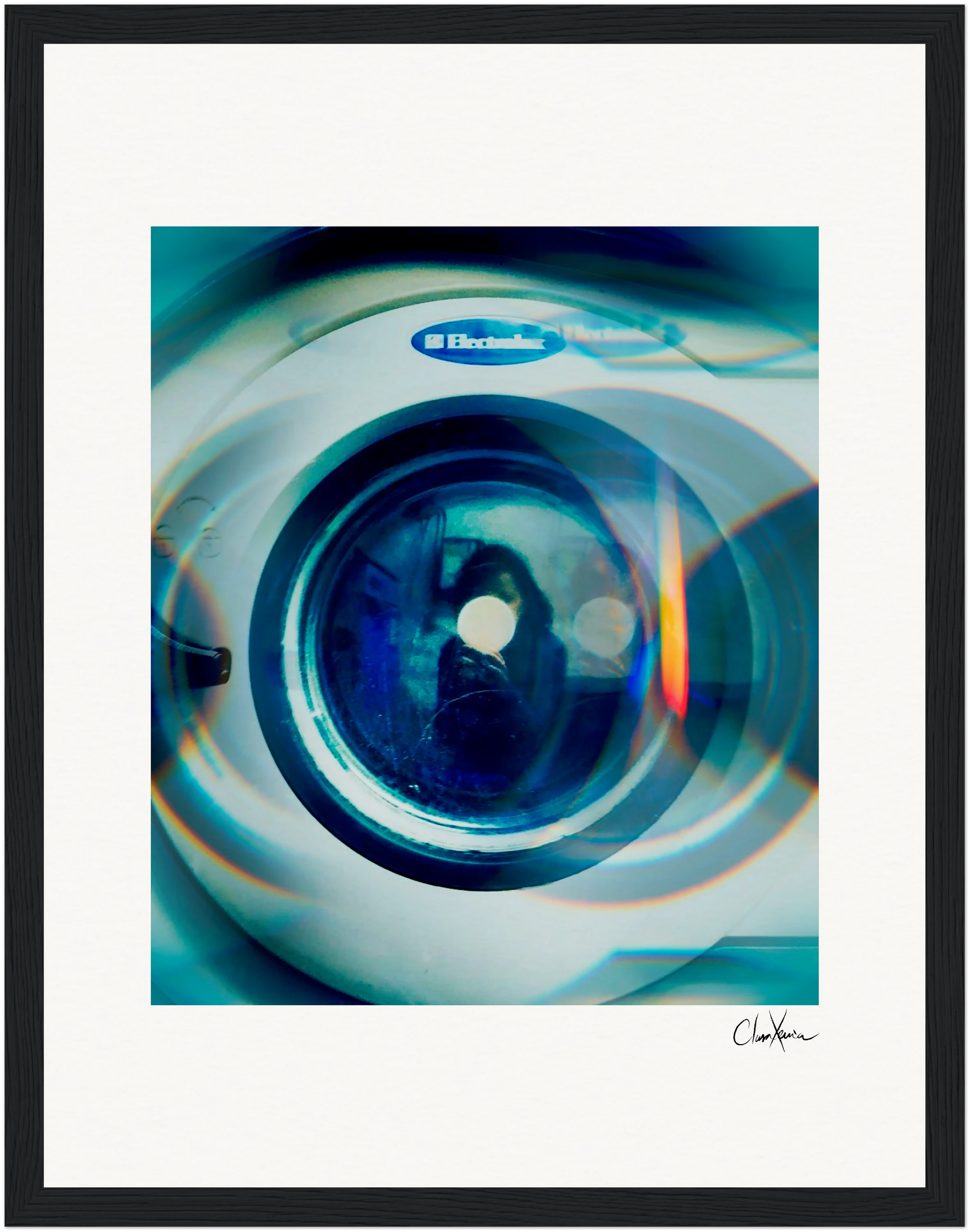 A front-loading Electrolux washing machine is shown close-up, with blue-green light effects on the door. The image features a gallery-quality frame and a signature at the bottom right, perfect as inspirational wall art.