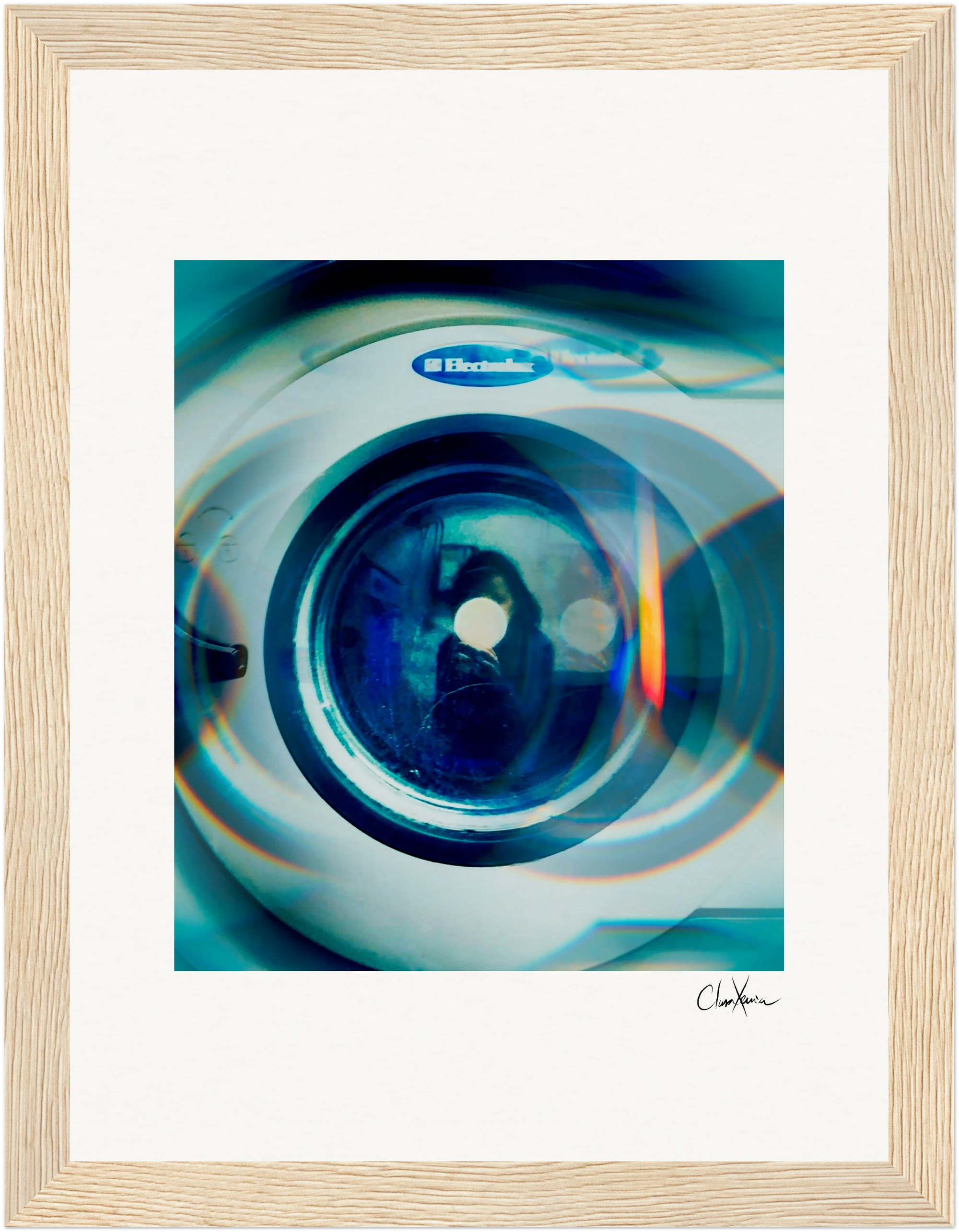 A close-up photo of an Electrolux washing machine door, with reflections and blue light, artistically framed in a gallery-quality frame with white matting. This fine art print offers a striking, abstract touch to your wall decor.