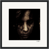A dark, grainy close-up of a person's face with long hair partially covering their features, set against a plain background and framed in black. This fine art print adds a sophisticated, contemplative touch to mindful home decor.