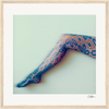 A single leg wearing black floral lace tights is extended against a plain light background. This inspirational wall art is beautifully presented in a gallery-quality frame, with a signature in the bottom right corner.