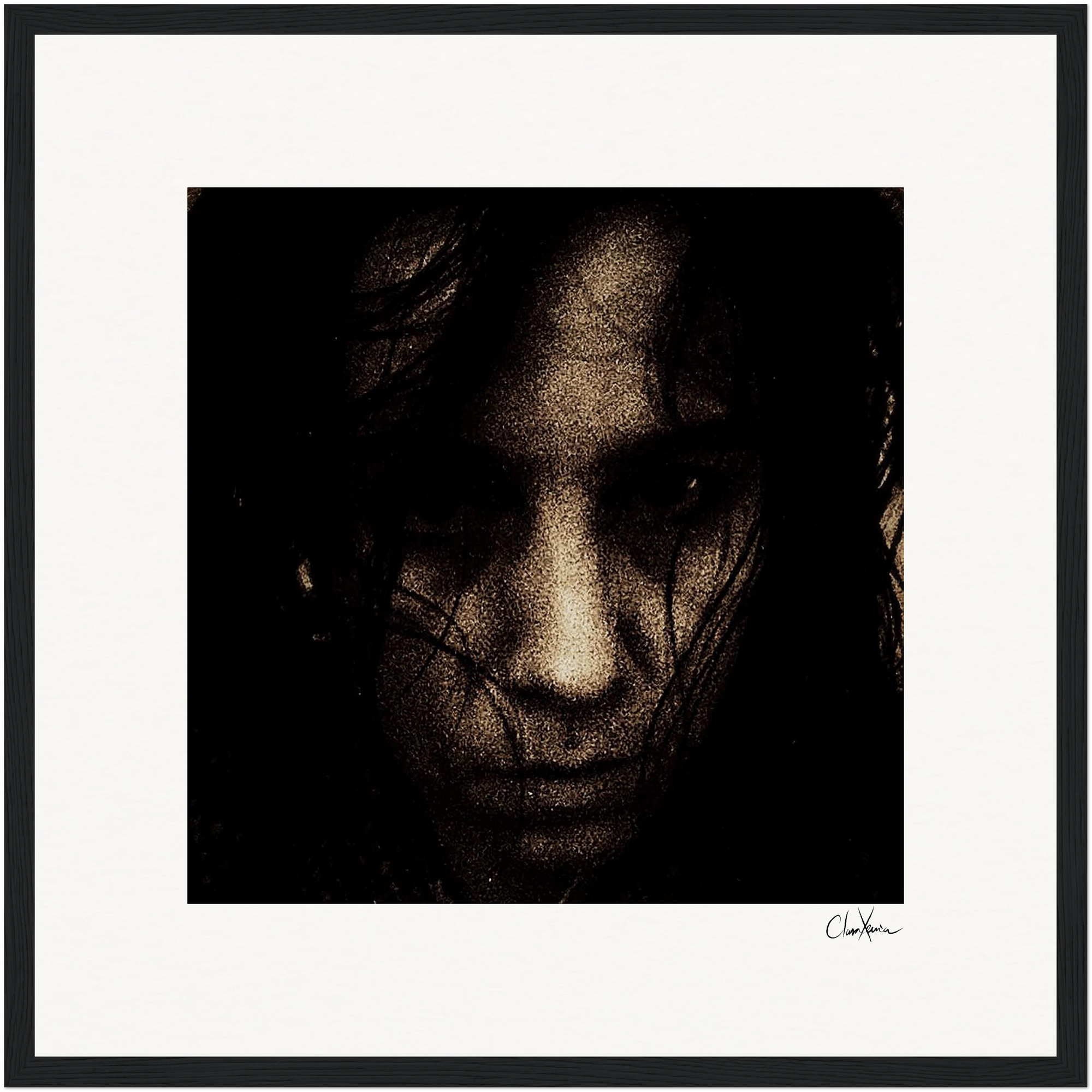 A dark, grainy close-up photograph of a person’s face with long hair partially covering it. The serious expression and moody, high-contrast atmosphere are enhanced by a gallery-quality frame and white mat, creating a striking fine art print.
