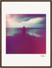 A silhouette of a person stands near the edge of a large body of water under a cloudy sky, with pink, purple, and blue tones. This dreamy, slightly blurred image makes for inspirational wall art or mindful home decor.