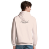 A person wearing a light-colored hoodie with the word Hopeful written in script on the back showcases conscious fashion. Seen from behind, they have short brown hair and are also wearing blue jeans.