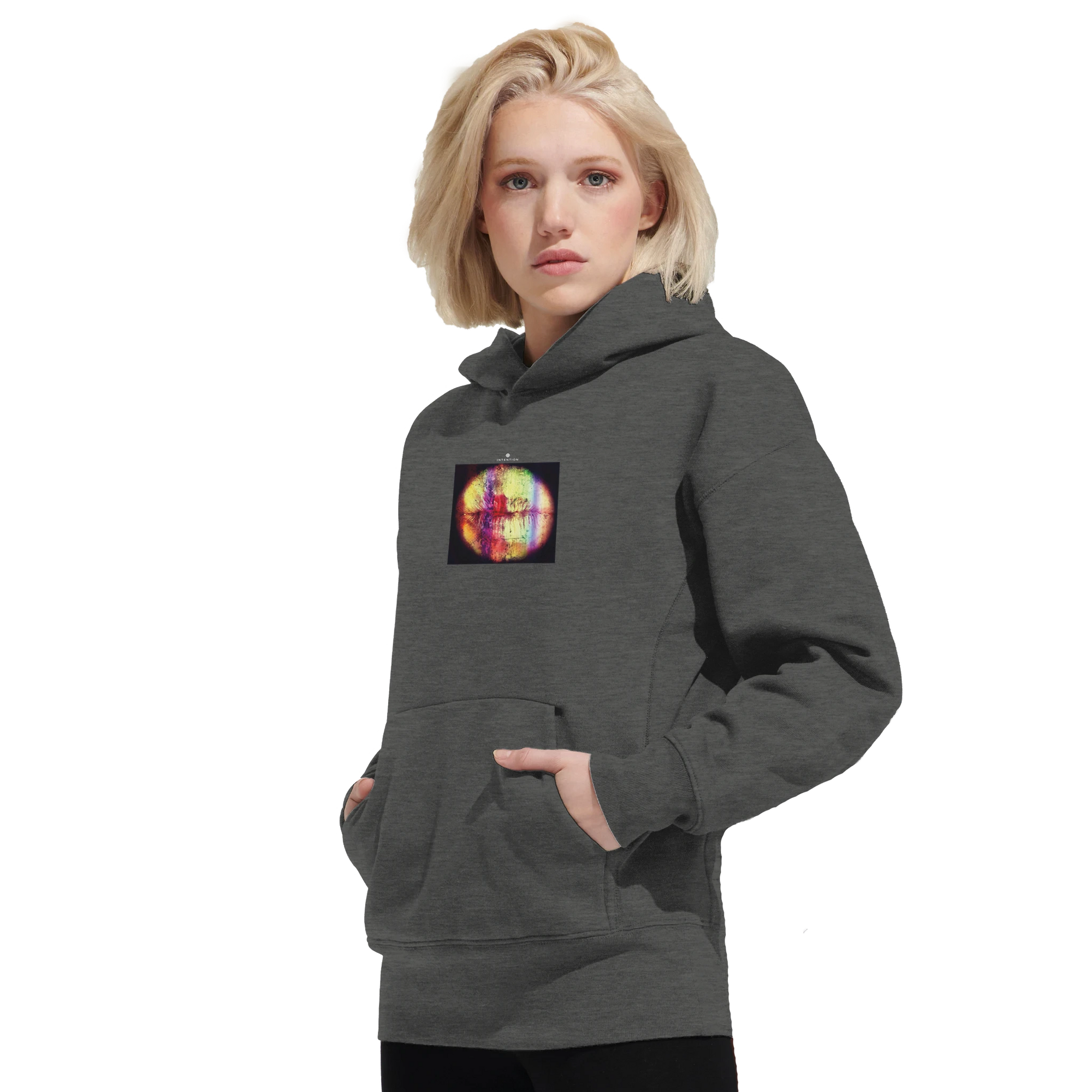 A person with blond hair wears a dark gray hoodie featuring a colorful abstract art print on the chest, standing against a plain white background.
