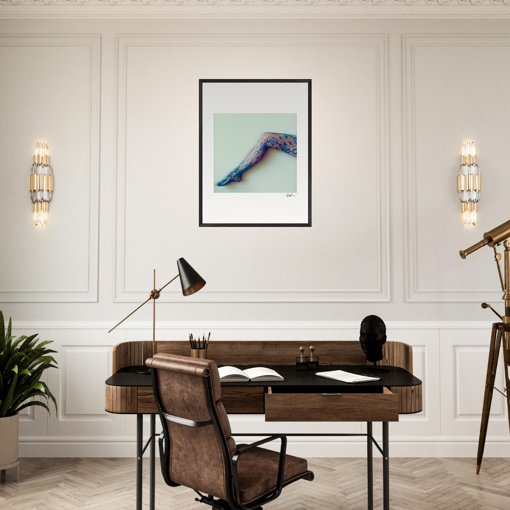 A modern home office featuring conscious interior design with a wooden desk, brown leather chair, black desk lamp, and mindful home decor. A fine art print of a patterned foot and ankle hangs above the desk, accented by wall sconces and a telescope.