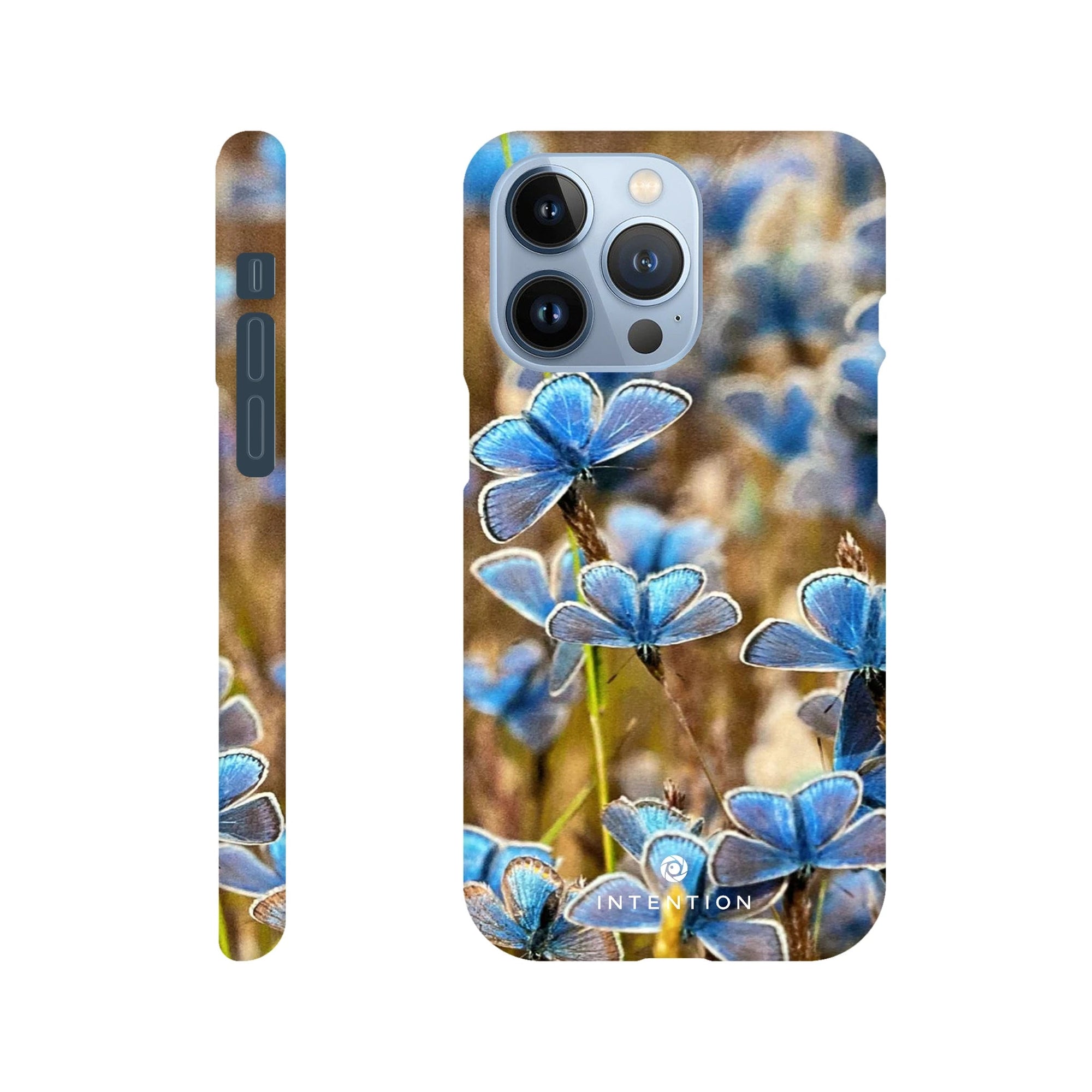 A phone case featuring a photo art close-up of multiple blue butterflies on grass, shown from the back and side angles. The word INTENTION appears near the bottom of the back, highlighting beautiful textures.