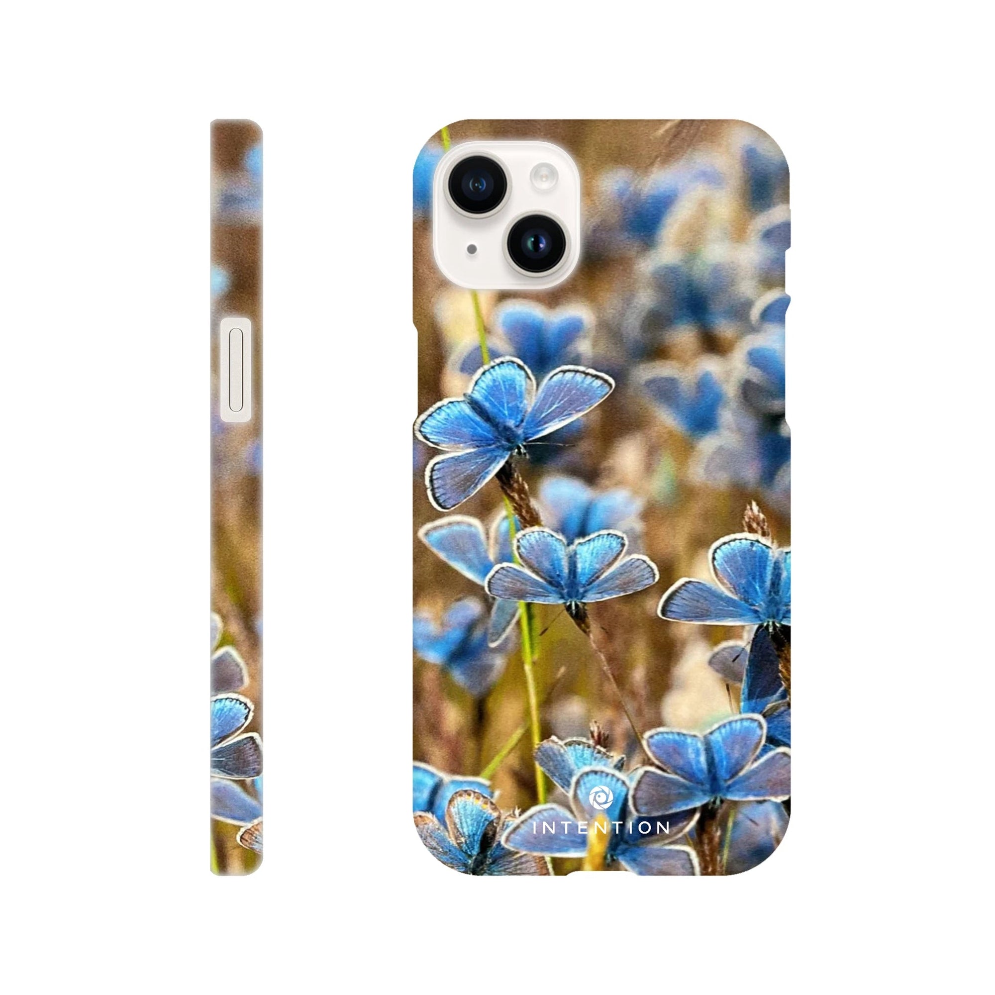 A phone case featuring photo art with a close-up of blue butterflies on grass, shown from the back and side angles against a white background. The word INTENTION appears near the bottom, highlighting beautiful textures in the design.
