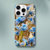 A smartphone with a case featuring a photo art close-up of several blue butterflies on flowers. The word INTENTION and a small circular design are printed near the bottom, highlighting delicate textures in the artwork.