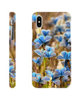 A phone case shown from the back and sides features a photo art pattern of blue butterflies resting on grass, with camera and button cutouts visible. The soft brown background enhances the textures, and the Inninoh logo is at the bottom.