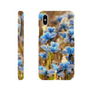 A phone case shown from the back and sides features a photo art pattern of blue butterflies resting on grass, with camera and button cutouts visible. The soft brown background enhances the textures, and the Inninoh logo is at the bottom.