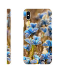 Phone case featuring photo art with a close-up of small blue butterflies on grass, highlighting delicate textures. Shown from back and side angles against a white background, with the word INTENTION near the bottom on the back view.