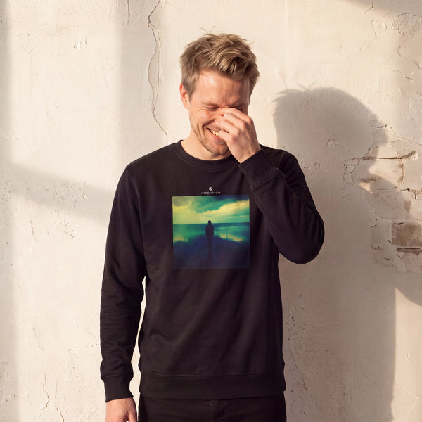 Calm - "Emerald Storms" Black Sweatshirt worn against a sunlit plaster wall
