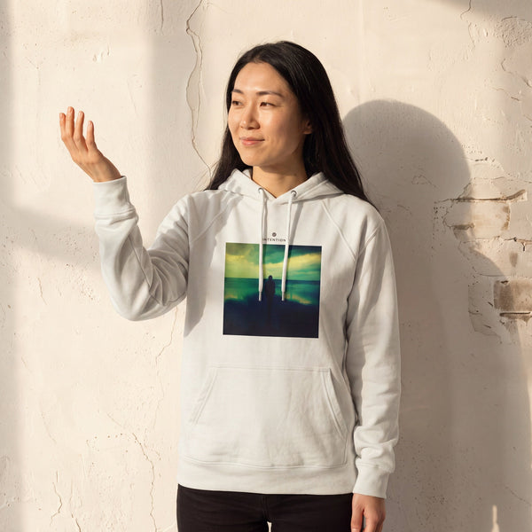 Calm - "Emerald Storms" Off White Hoodie worn against a sunlit plaster wall