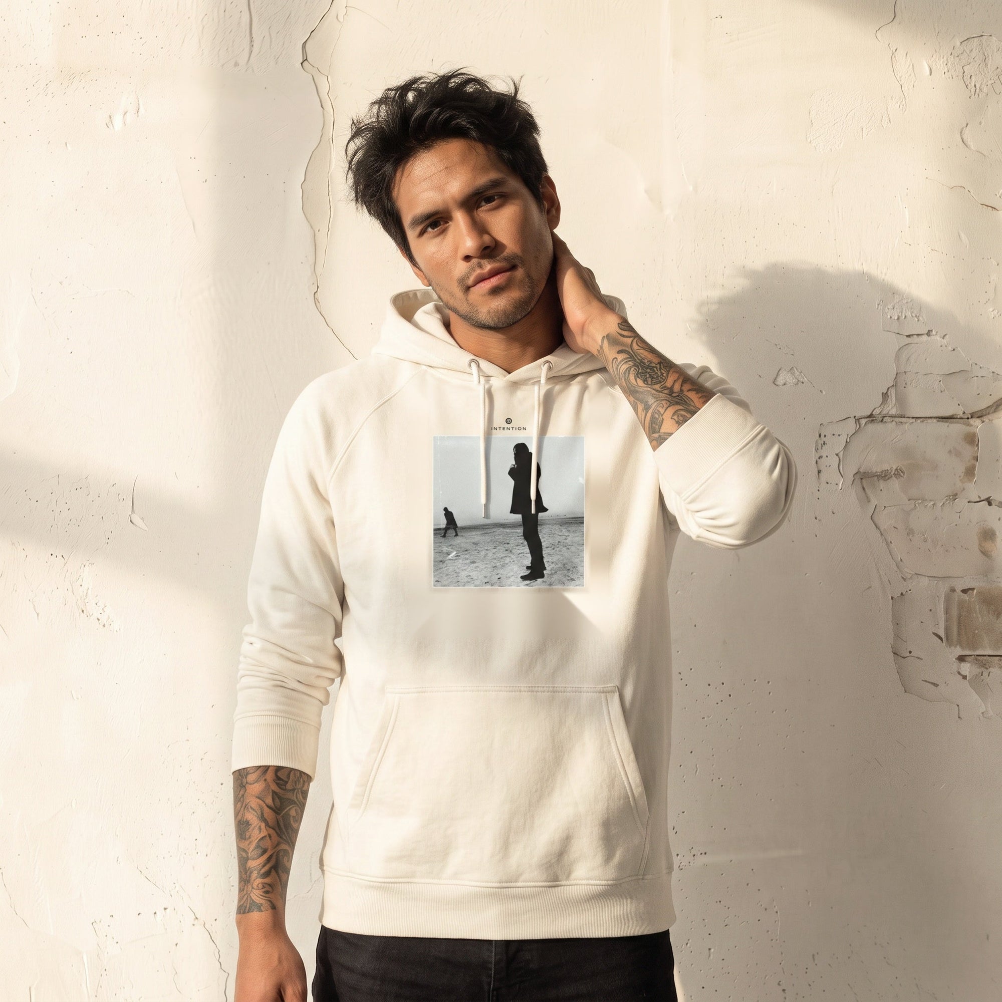 Compassion - "The Space We Share" Off White Hoodie worn against a sunlit plaster wall