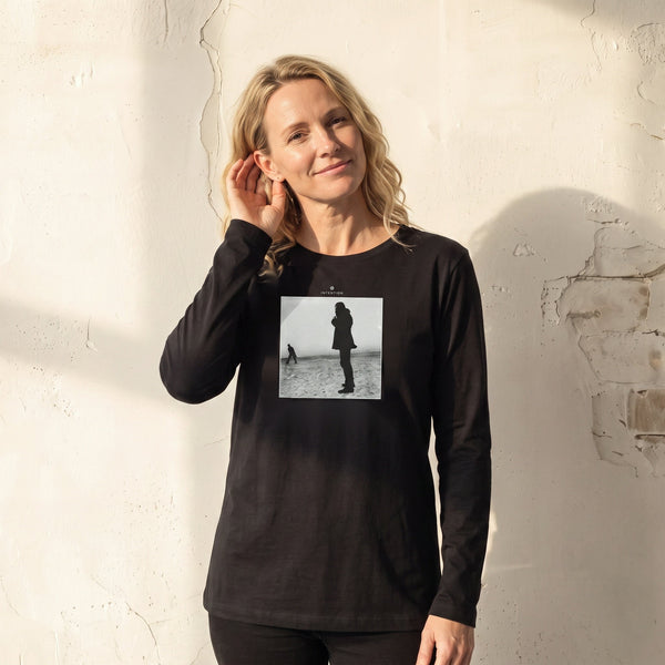 Compassion - "The Space We Share" Deep Black Long Sleeve worn against a sunlit plaster wall