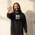 Compassion - "The Space We Share" Black Hoodie worn against a sunlit plaster wall