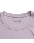 A close-up of the neckline of an organic lavender t-shirt, featuring the word Serenity printed inside the collar in blue cursive—an elegant detail for conscious fashion lovers.