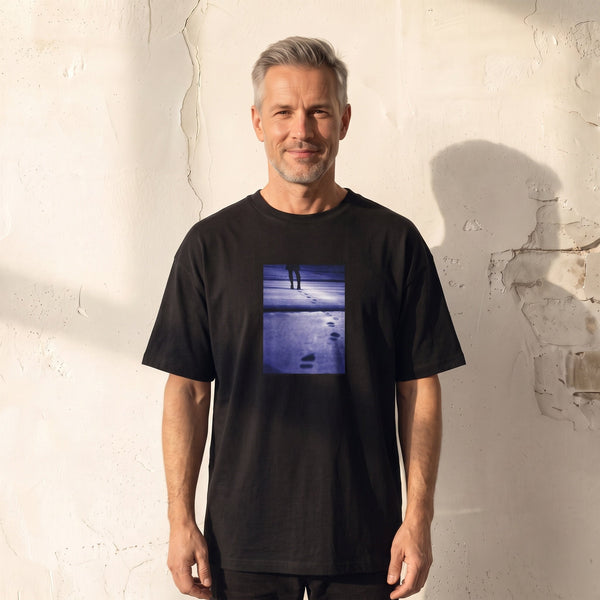 Faith - "The Unwritten Path" Deep Black T-shirt worn against a sunlit plaster wall