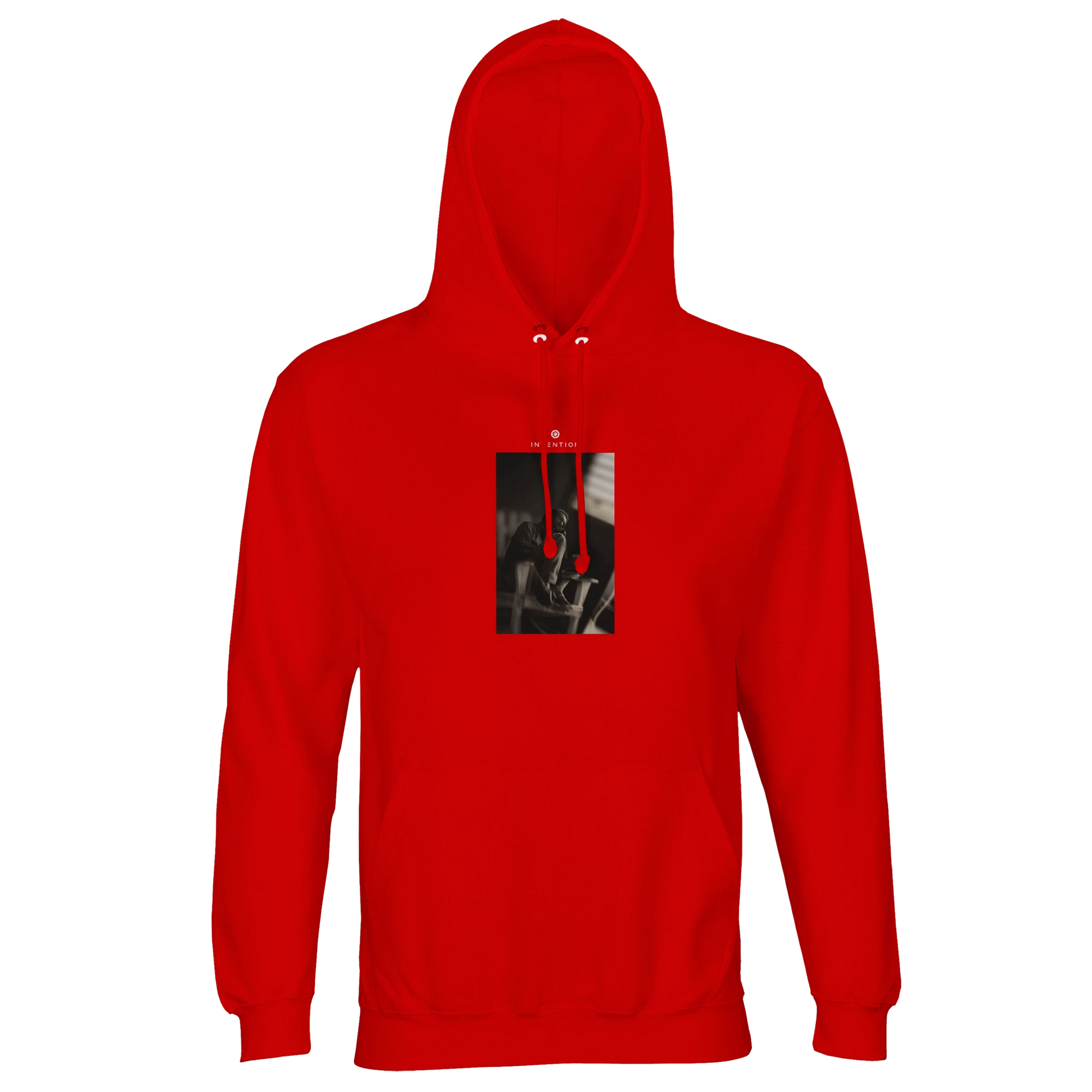 A bright red hooded sweatshirt with a front pocket and an abstract black and white art print on the chest features red drawstrings. Made from organic material, it's shown on a plain white background.