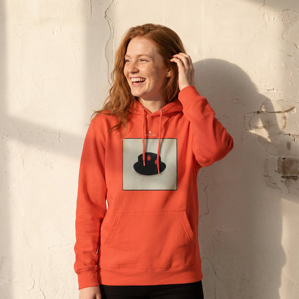 Freedom - "Hat On" pop orange Hoodie worn against a sunlit plaster wall